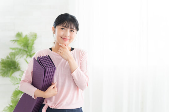 考えるヨガウェアの若い女性