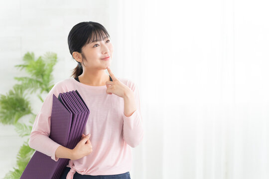 考えるヨガウェアの若い女性
