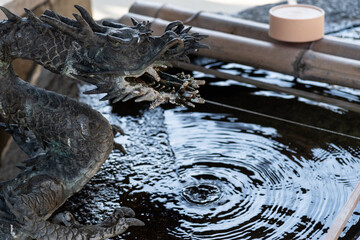 日本の神社、手水舎の龍の吐水口と水の滴り © rai