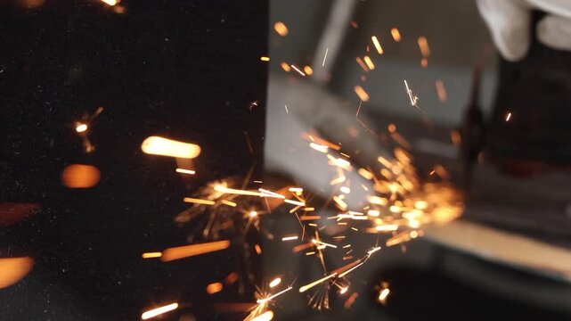 Golden sparks flying in motion blur during metal grinding or welding process