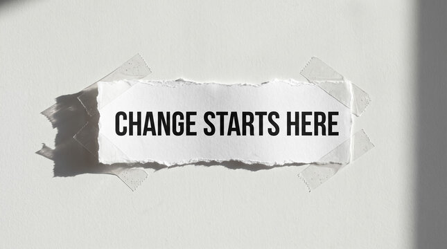 Torn paper message taped on wall saying change starts here symbolizing motivation, new beginning, and transformation concepts