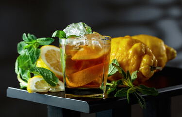 Iced black tea with lemon wedges, ice cubes and mint leaves. © Igor Normann