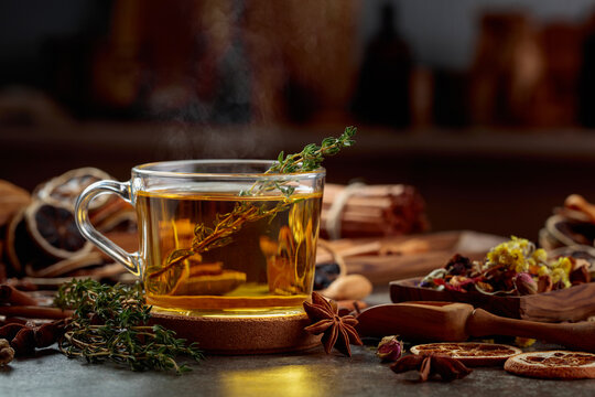 Cup of herbal tea with ingredients on the kitchen table.