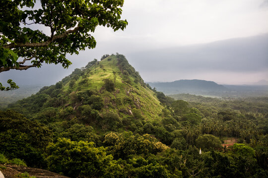Lush Green Mountain Peak Overlooking a Verdant Valley Under Cloudy Skies