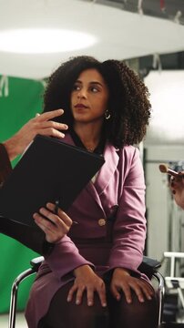 People, producer and model in studio with clipboard, screenplay and change script for production. Team, stylist or makeup in bts with catalog, director advice and review dialogue for filming briefing