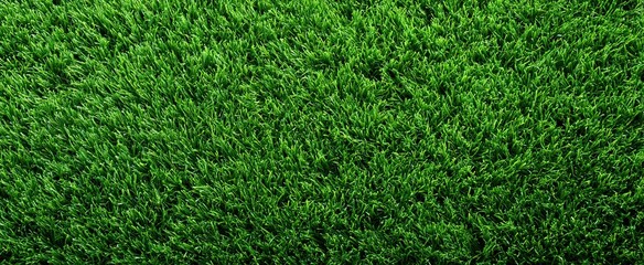Obraz premium Synthetic bright green turf viewed from above, highlighting uniform texture and vibrant color for sports use.