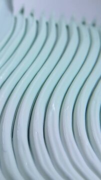 Top close up of creating a zigzag spiral wavy pattern on beauty cream. Detailed texture manipulation, artistic skincare product presentation for beauty concept.