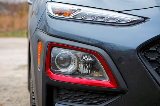 headlight of modern prestigious car closeup. beautiful headlights of a car. dark gray color, red edging. part of the front, the car is unrecognizable. direction indicators on a sports car