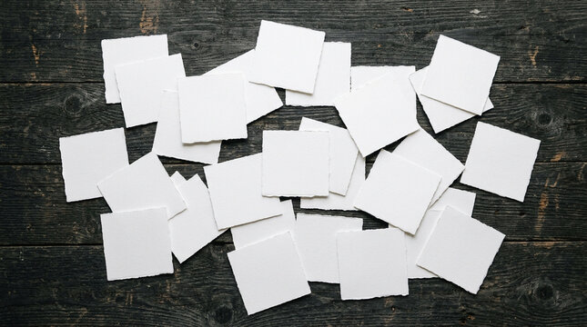 Blank white paper squares on dark wood. Empty note cards for creative design mockups.