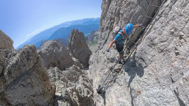 Hiker climbing the famous Scala degli Amici on Via Ferrata Bocchette Alte, Brenta Dolomites