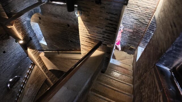 tourist woman on the stairs of the panoramic view inside the Ghirlandina bell tower, showcasing the striking architecture of Modena's revered Duomo cathedral of Modena city in Italy
