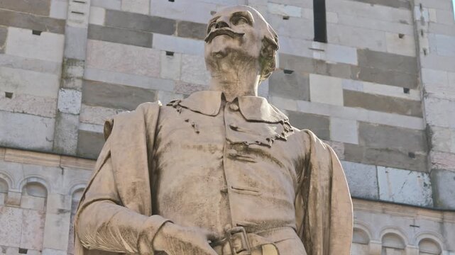 The captivating downtown of Modena, Italy, showcasing the famous statue of Alessandro Tassoni by the sculptor Alessandro Cavazza from 1860. Modena cathedral bell tower and the of Modena city in Italy