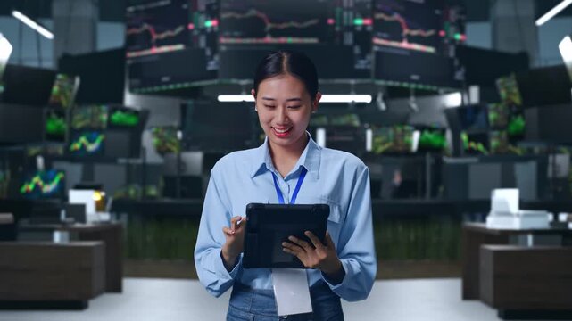 Asian Female With Her Tablet at Financial Trading Control Room, Work Continuously With Her Tablet