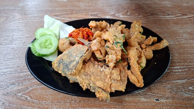 Gurame Saos Telur Asin. Crispy fried gourami fish covered with salted egg sauce. Indonesian food