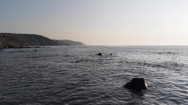 Low tide and waves on rocks at Widemouth Bay South West UK