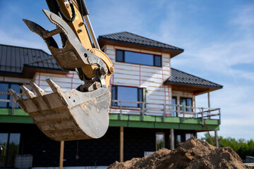 Obraz premium Excavator Bucket at Modern House Construction Site