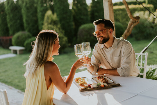 Couple enjoying a romantic dinner outdoors with delicious food and wine