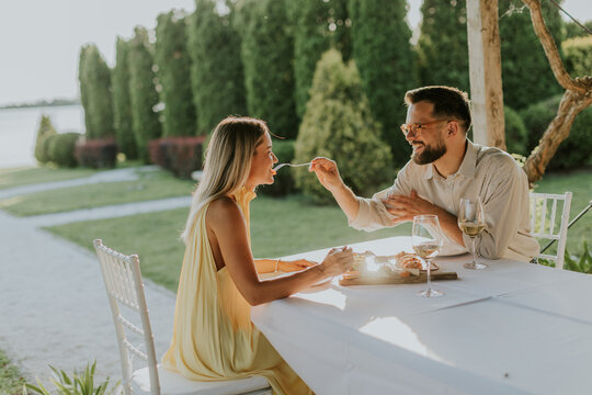 Couple enjoying a romantic dinner by the lake at sunset