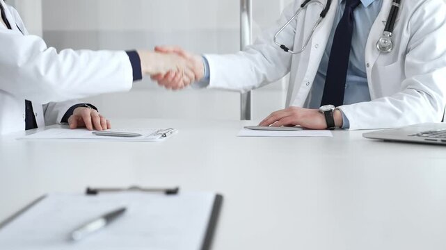 Doctors shaking hands, symbolizing partnership, trust, and successful agreement in a healthcare setting. Medical team meeting