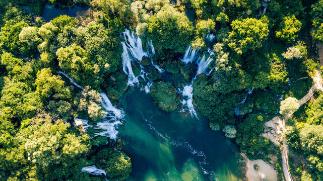 Top down aerial view of emerald pools beneath spectacular cascading waterfalls