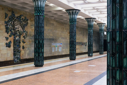 Ornate Gafur Gulom metro station interior with green ceramic columns and sculptural wall relief in Tashkent, Uzbekistan. Empty platform showcases Soviet-era decorative architecture ideal for travel.