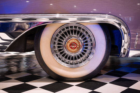 Close-up of a classic Cadillac Eldorado wire wheel with wide whitewall tire and polished chrome fender trim.