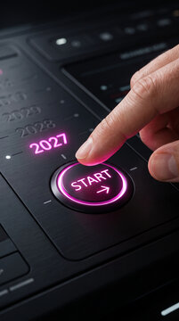 Finger pressing a glowing pink "START" button with "2027" illuminated, symbolizing a new beginning or future launch.