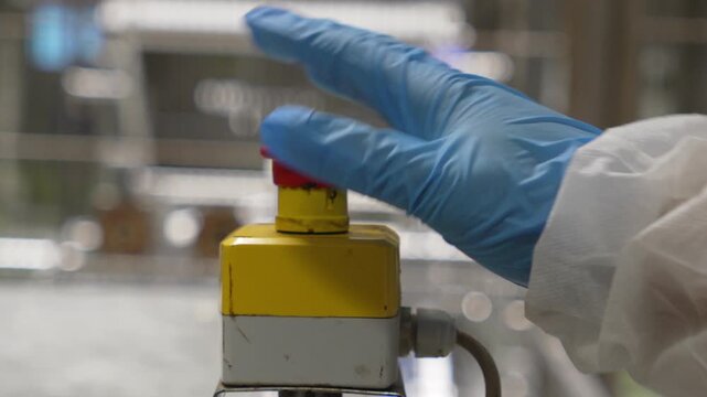 Industrial machine emergency stop button pressed, slow motion