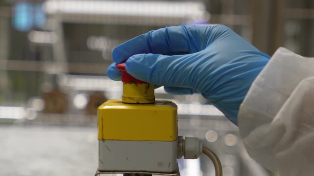 Technician rotating and resetting emergency stop button, slow motion