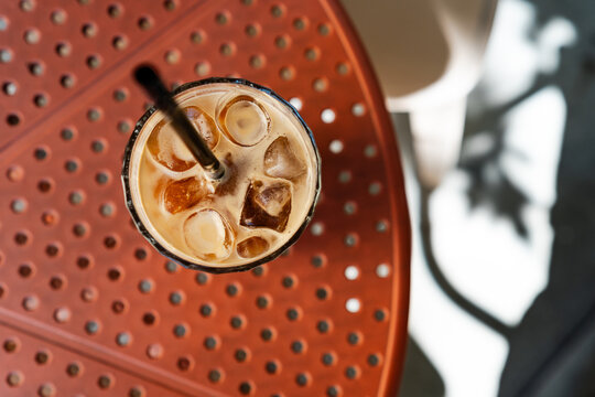 Top view of iced espresso tonic coffee glass on a terracotta table
