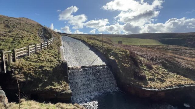 Riverside dam cascades water down a stone slope