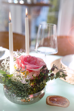 Romantic wedding table decoration. Special event table setting. Arrangement with fresh pink roses and candlelight. Vertical close-up with short depht of field.