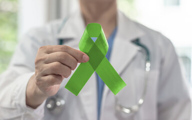 Obraz premium Lime green ribbon for awareness on Mental health illness, Lymphoma Cancer, Lyme Disease, Spinal Cord Injuries, Kabuki Syndrome, Duchenne Muscular Dystrophy, Sexually Transmitted diseases