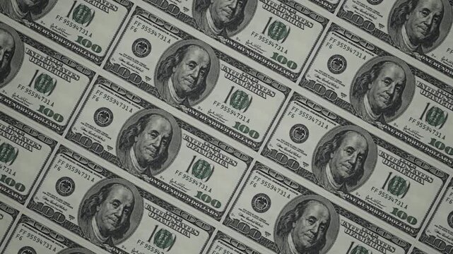 CGI of $100 bills in a tiled pattern. Camera glides over banknotes showing engraving and security details. Ideal for finance and wealth content. Rendered in Unreal Engine.