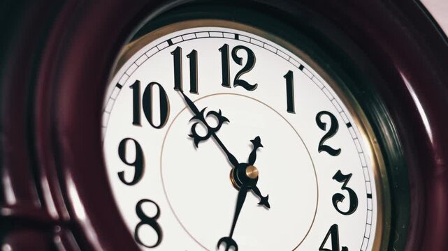 Close-up time lapse shows black ornate hands of a vintage analog clock spinning rapidly around a white dial. The dark wooden frame enhances the classic aesthetic.