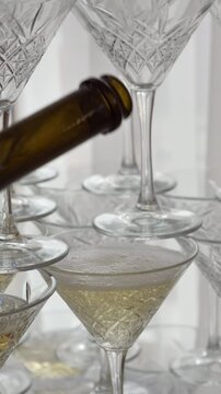 Pouring champagne into a crystal glass pyramid at a wedding