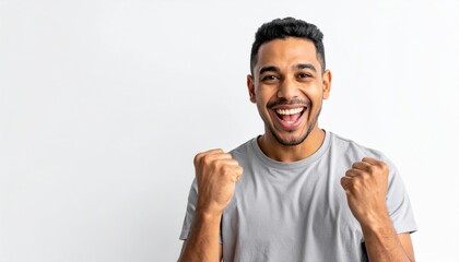 Fototapeta premium A triumphant man exulting over a major win, smiling brightly with fists clenched in a passionate celebration gesture on white.