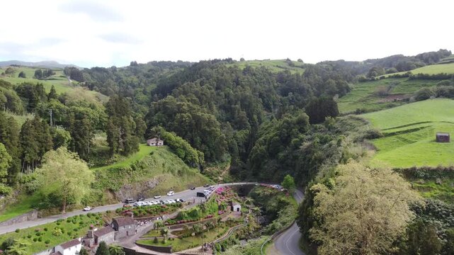 Aerial view of beautiful tropical waterfall surrounded by lush green forest in Ribeira dos Caldeiroes