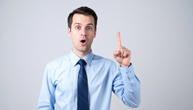 A young businessman suddenly pointing his index finger up in the air, expressing a brilliant new creative idea.
