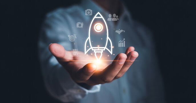 Businessman hand holding rocket icon, start up and business idea development concept.