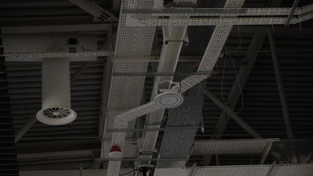 Exposed ceiling engineering systems with ventilation ducts, cable trays and utility infrastructure inside modern commercial or industrial building
