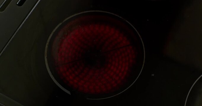 Ceramic hob electric stove burner heating up to bright glowing red