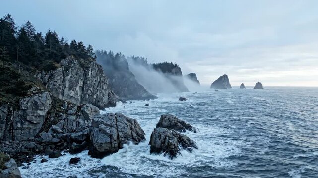 Rocky coastline with crashing waves and sea mist flowing along dramatic cliffs for nature and travel content