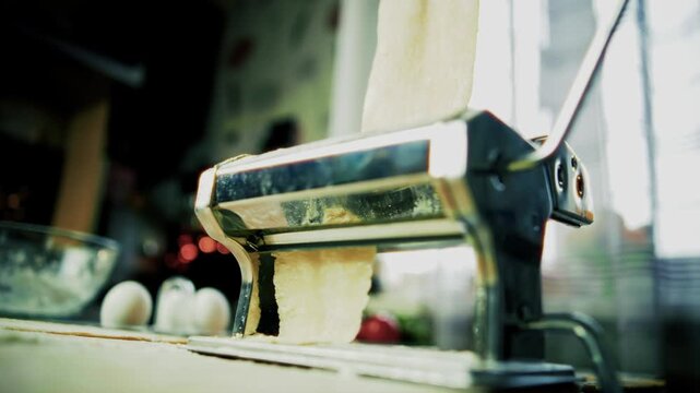 Rolling Fresh Dough Through Manual Pasta Machine. Making Homemade Noodles
