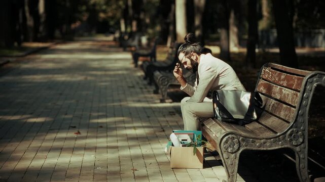 Fired Businessman Sitting On Park Bench. Job Loss. Professional Stress 