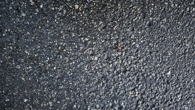 Wet road asphalt surface texture close up, simple elegant abstract background