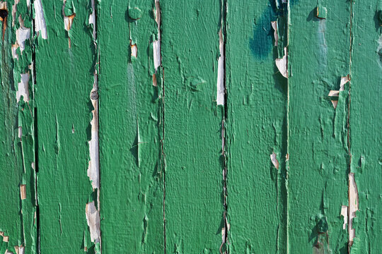 Peeling green paint on vertical wooden boards background