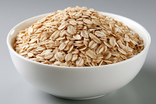 Piles of oats in a white bowl on a gray background