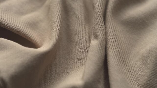 A close-up texture of soft wrinkled beige jersey fabric