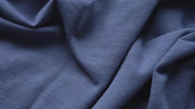 A close-up texture of soft wrinkled blue jersey fabric.